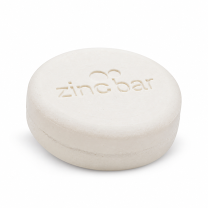 DermaHarmony Pyrithione Zinc 2% Face & Body Cleansing Bar 113 g - A single white round soap bar with an imprint
