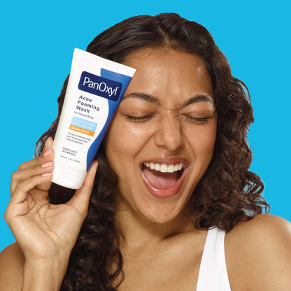 Woman holding PanOxyl Acne Foaming Wash 10% Benzoyl Peroxide 5.5 oz